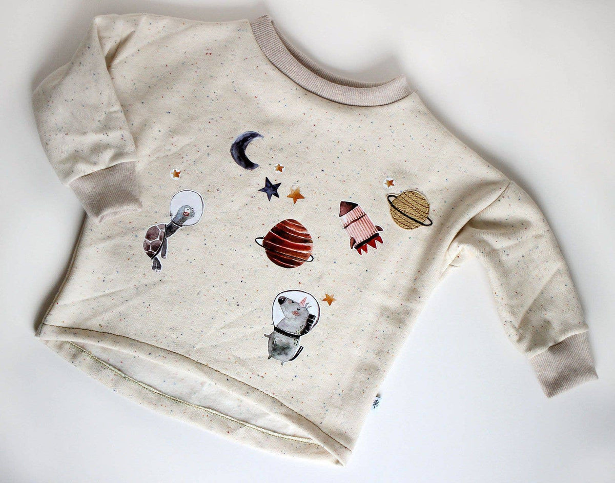 Das Bügelbild Astronaut Einhorn von Halfbird auf einem Kinderpullover als kreative Verzierung. Erhältlich im Bärechind Winterthur.
