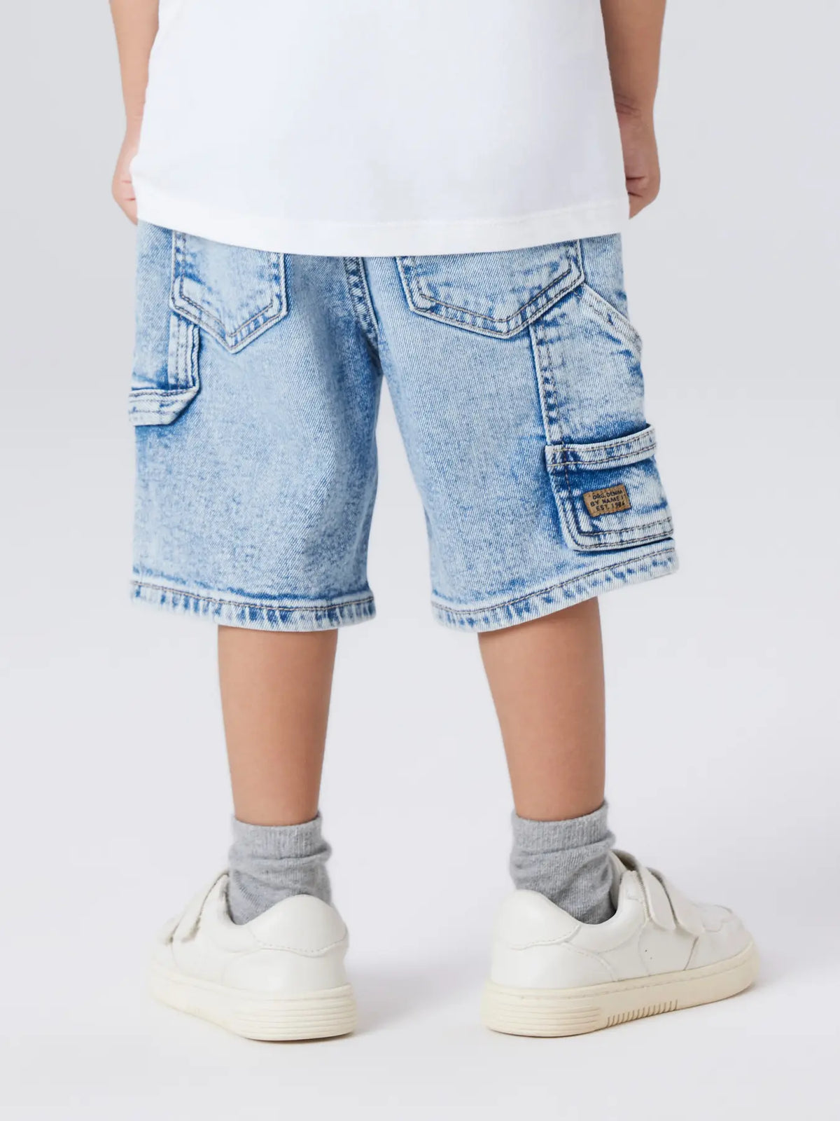 Kind trägt hellblaue Denim Jeans Bermuda im Sommer Outfit, erhältlich bei Bärechind Winterthur Zürich Schweiz.