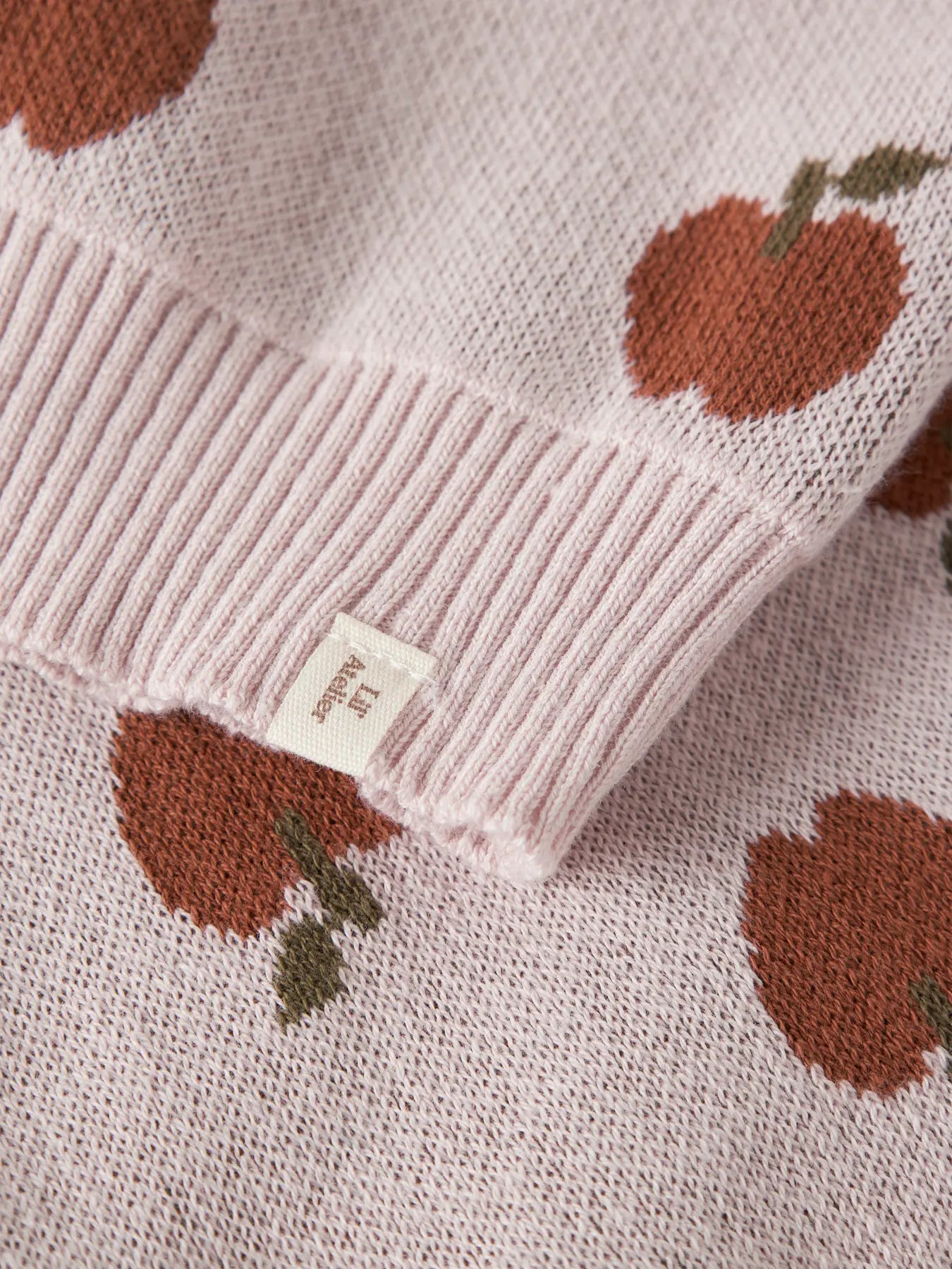 Detailaufnahme des Apfelmusters auf einem LIL'ATELIER Strickpullover bei Bärechind Winterthur Zürich Schweiz