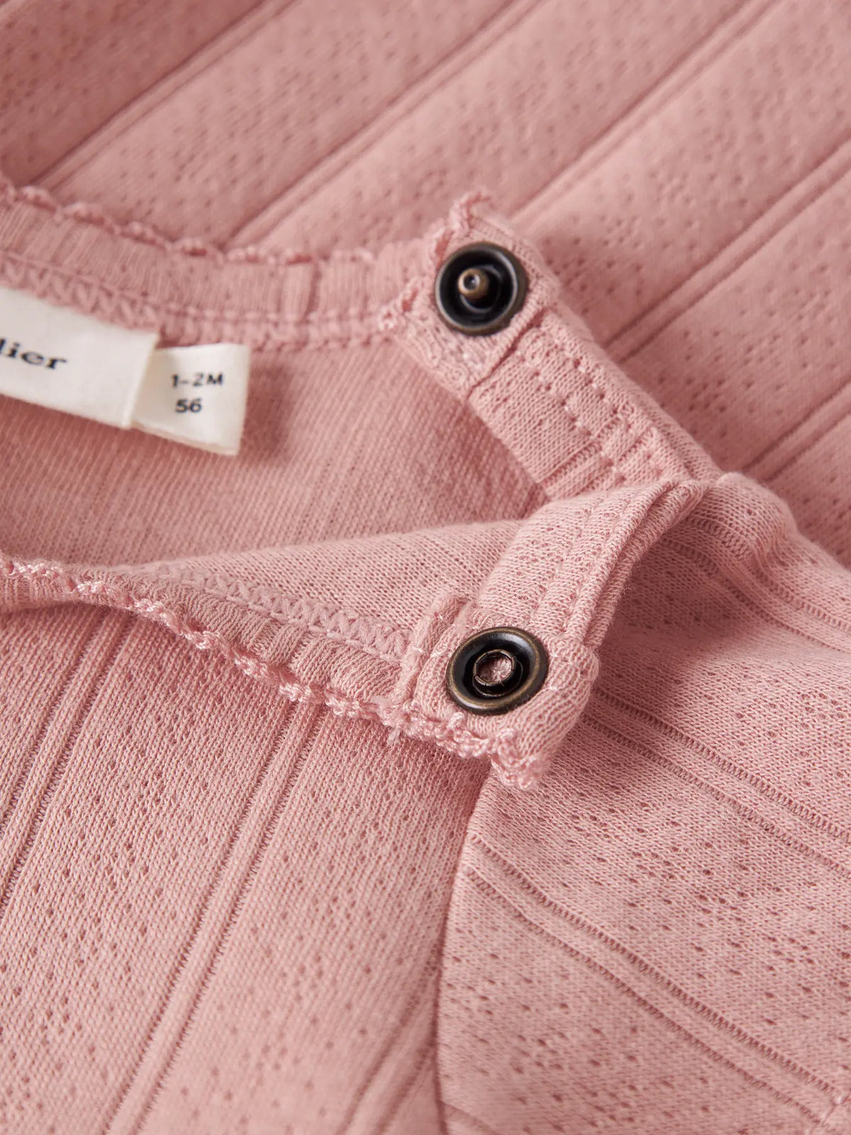 Detailaufnahme Druckknöpfe am Lil' Atelier Baby Bodykleid aus Bio-Baumwolle bei Bärechind Winterthur Zürich Schweiz.