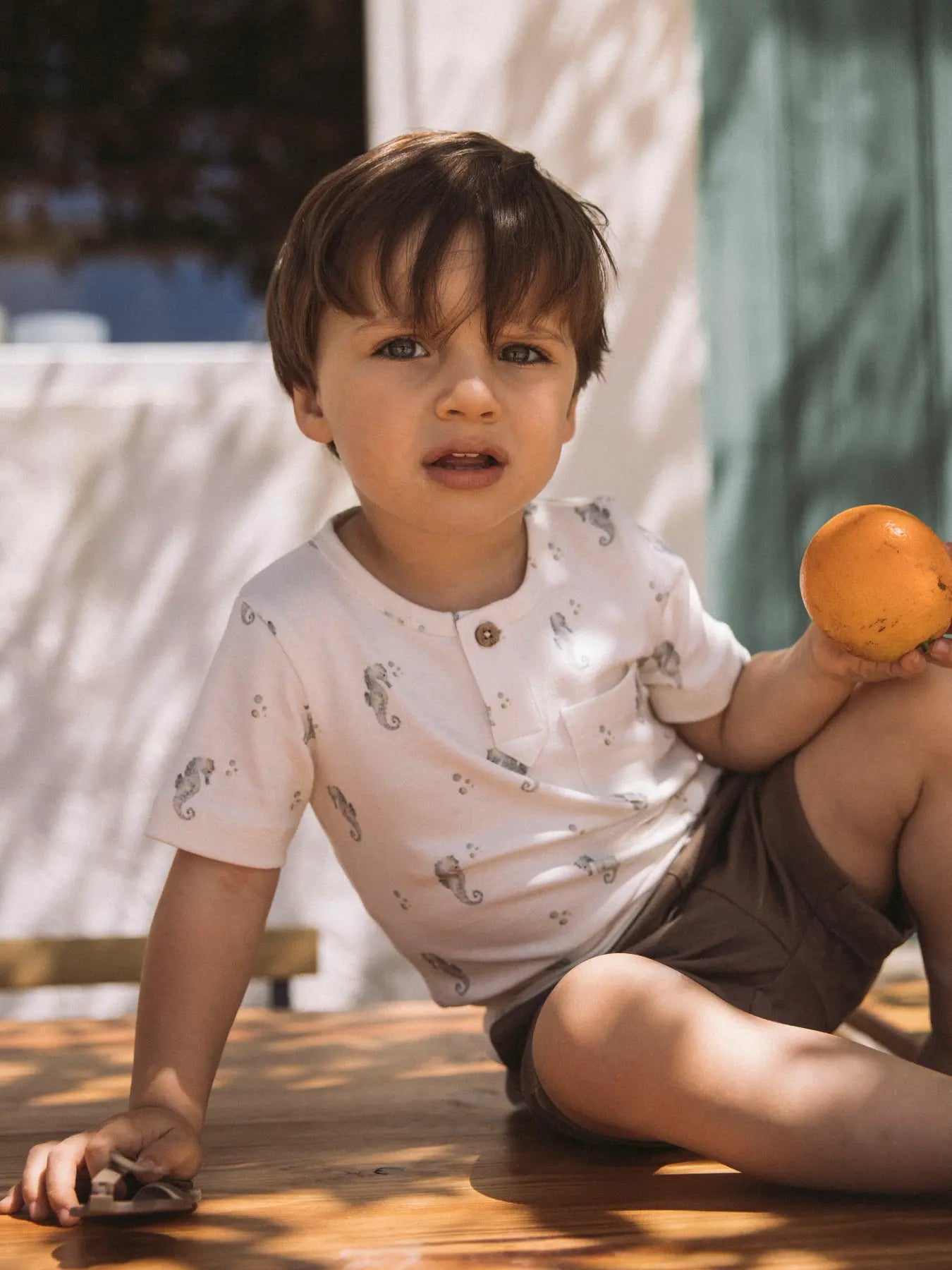 Kind trägt Lil' Atelier T-Shirt mit Seepferdchen Muster, nachhaltige Kindermode bei Bärechind Winterthur Zürich Schweiz.