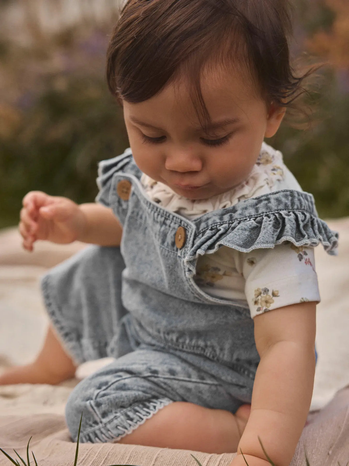 Baby trägt blaue Denim Latzshorts von Lil’Atelier im Sommerlook, erhältlich bei Bärechind in Winterthur, Zürich, Schweiz