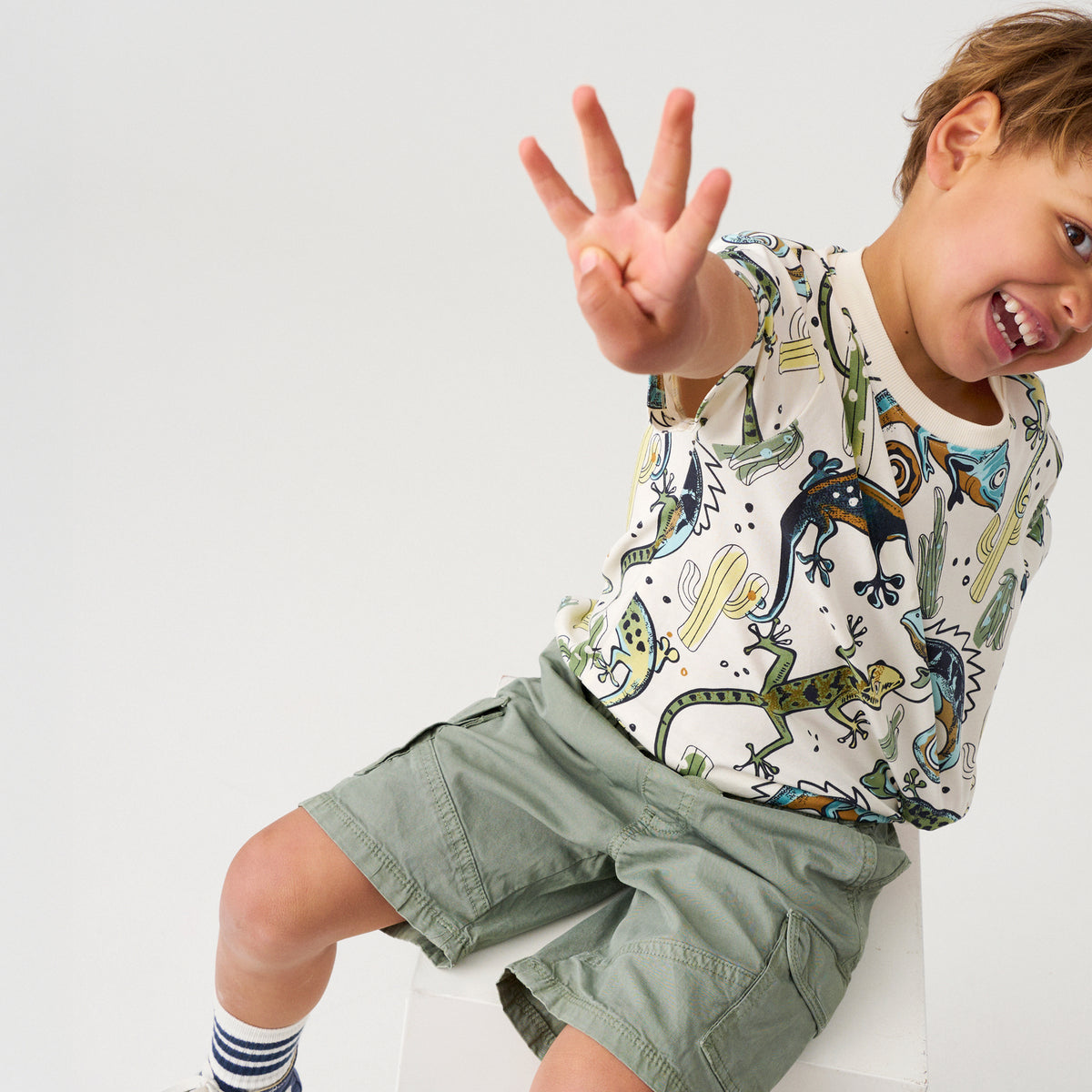 Kind trägt Minymo T-Shirt mit Reptilien Print, nachhaltige Kindermode im Bärechind Winterthur Zürich Schweiz.