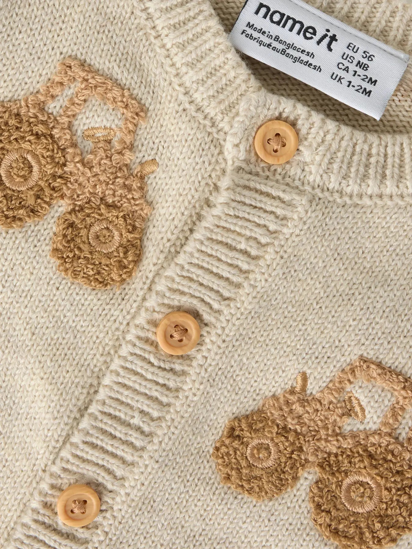 Detailaufnahme der Traktorstickerei und Knopfleiste der NAME IT Strickjacke, erhältlich im Bärechind.