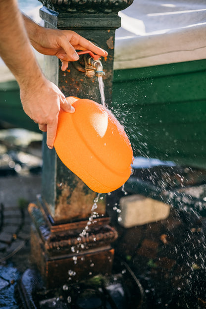 Spielen am Wasser mit dem orangen Stapelstein – wasserfest, leicht und kreativ einsetzbar. Im Bärechind in Winterthur erhältlich.