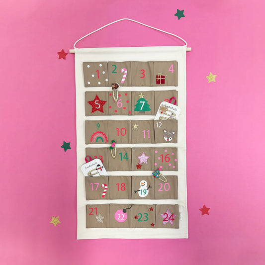 Adventskalender mit Haarclips und Haargummis vor pinkem Hintergrund – erhältlich bei Bärechind Winterthur Zürich Schweiz.