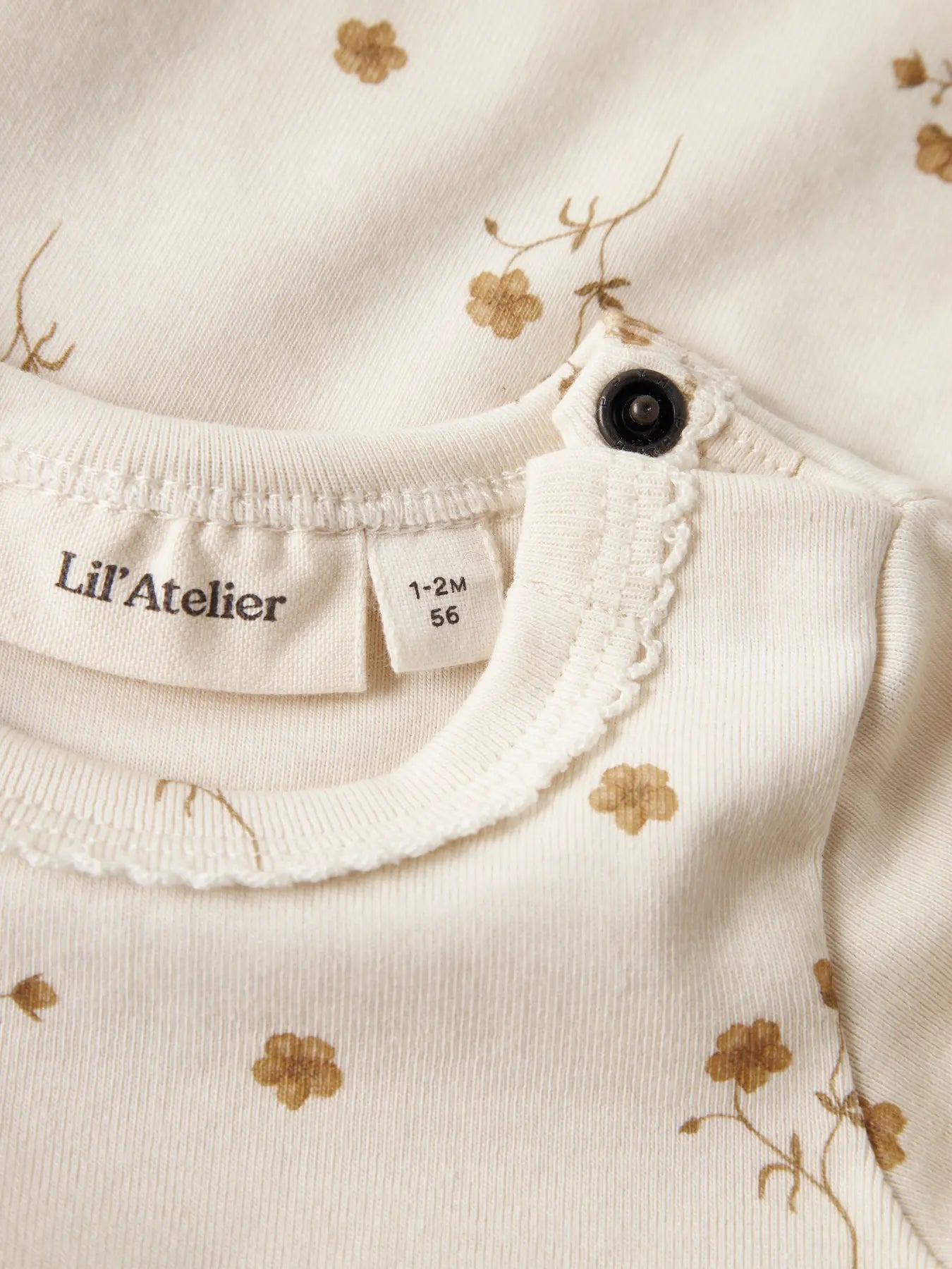 Detailaufnahme des Baby Bodys mit Blumenprint aus Bio-Baumwolle von Lil’ Atelier bei Bärechind Winterthur, Zürich, Schweiz.