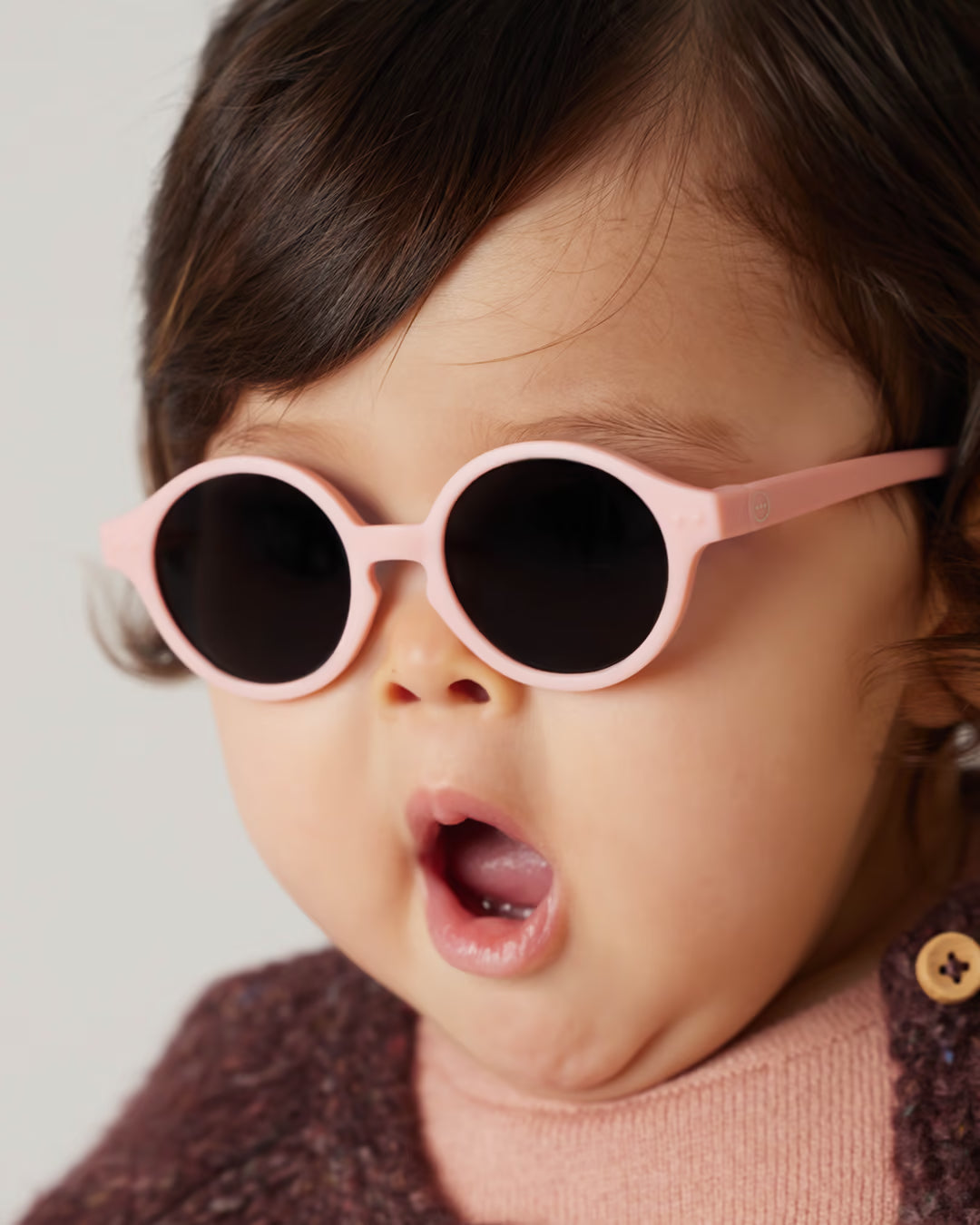 Baby trägt pinke Sonnenbrille von Izipizi draussen Bärechind Winterthur Zürich Schweiz kaufen