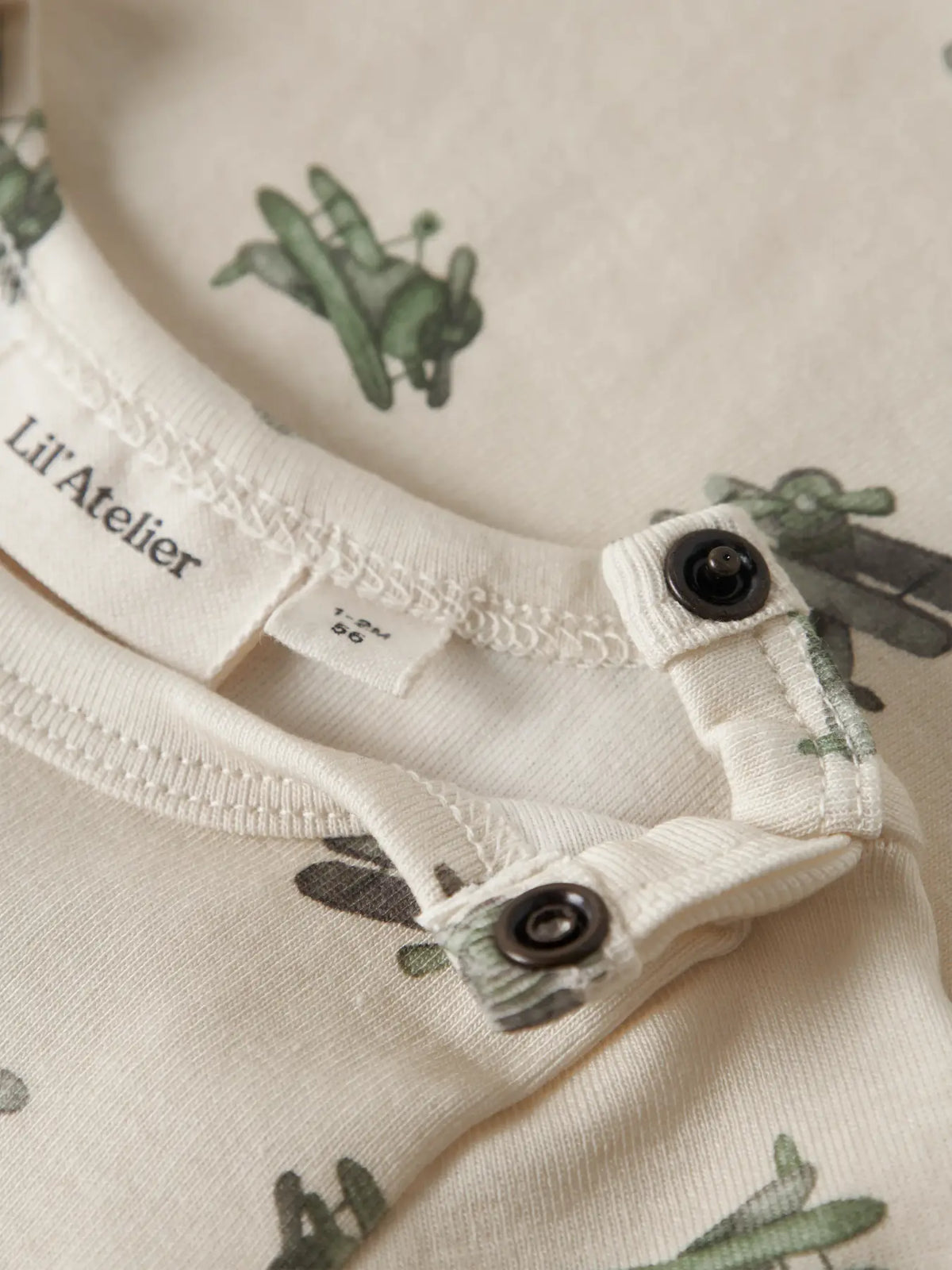 Detailansicht Flugzeug-Print und Druckknöpfe am Babybody von Lil’ Atelier im Bärechind Winterthur Zürich Schweiz