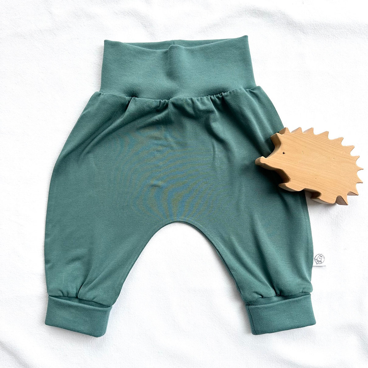 Die Babyhose aus weichem Material in Salbeigrün bietet viel Bewegungsfreiheit und ist im Bärechind Winterthur erhältlich.