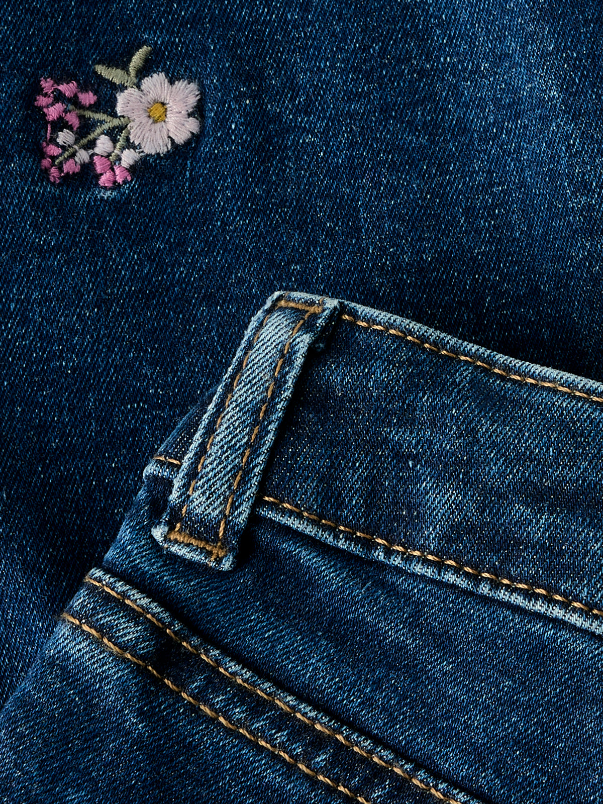 Vorderansicht der blauen Stretch Blumen Jeans im Mum Fit Schnitt von NAME IT, sehr dehnbar mit verstellbarem Bund, im Bärechind Winterthur, Zürich Schweiz erhältlich.