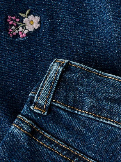 Vorderansicht der blauen Stretch Blumen Jeans im Mum Fit Schnitt von NAME IT, sehr dehnbar mit verstellbarem Bund, im Bärechind Winterthur, Zürich Schweiz erhältlich.
