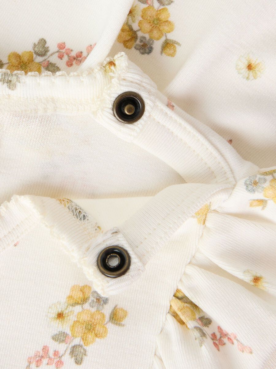 Detailaufnahme des Blumenmusters und der Druckknöpfe am Bodykleid von Lil' Atelier im Bärechind Winterthur Zürich Schweiz.