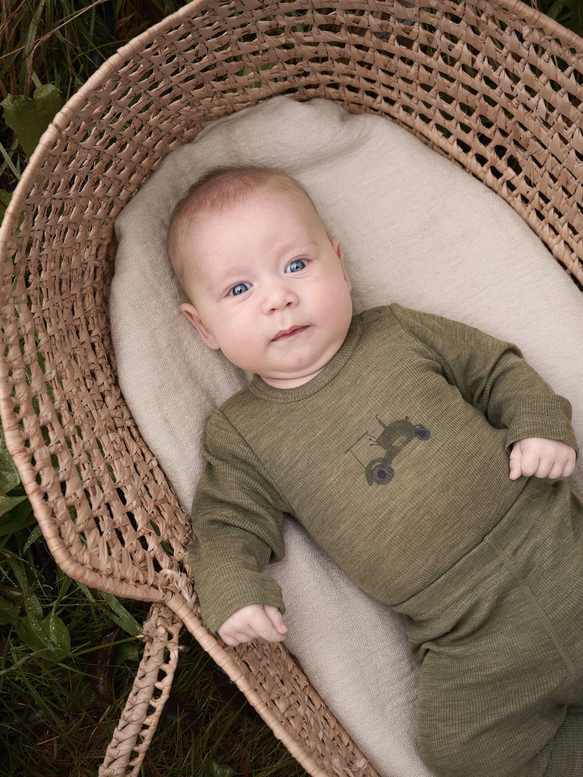 Baby trägt CeLaVi Langarmbody mit Traktormotiv in Dusky Green – zu finden im Bärechind in Winterthur, Zürich, Schweiz.