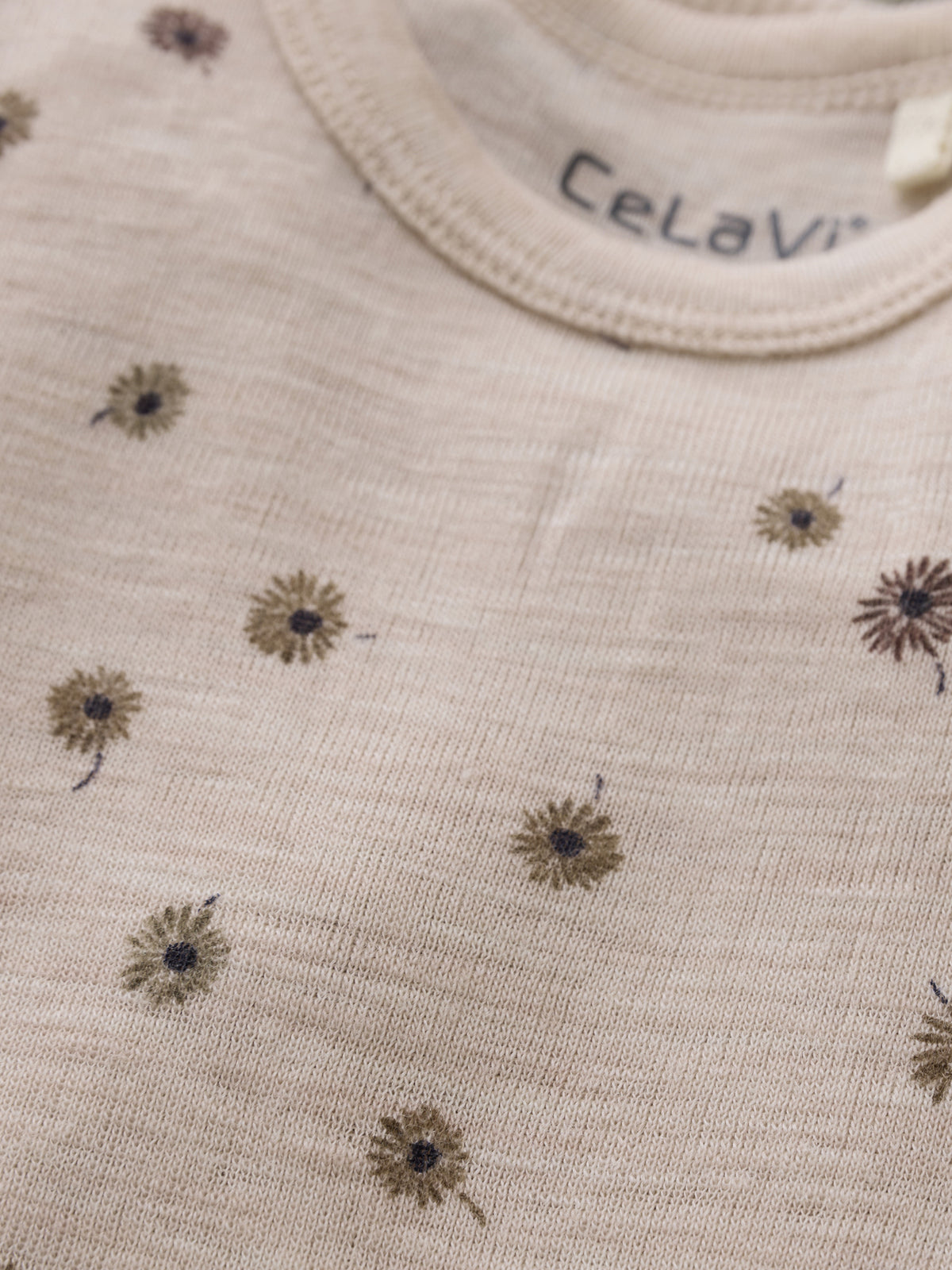 Detailansicht des CeLaVi Wollbodys mit Blumenmuster, erhältlich im Bärechind in Winterthur, Zürich Schweiz.