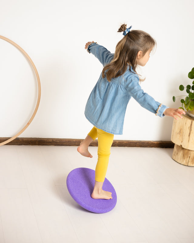 Kind balanciert auf dem lilafarbenen Balance Board – Bewegungsfreude und Spielzeit im Bärechind