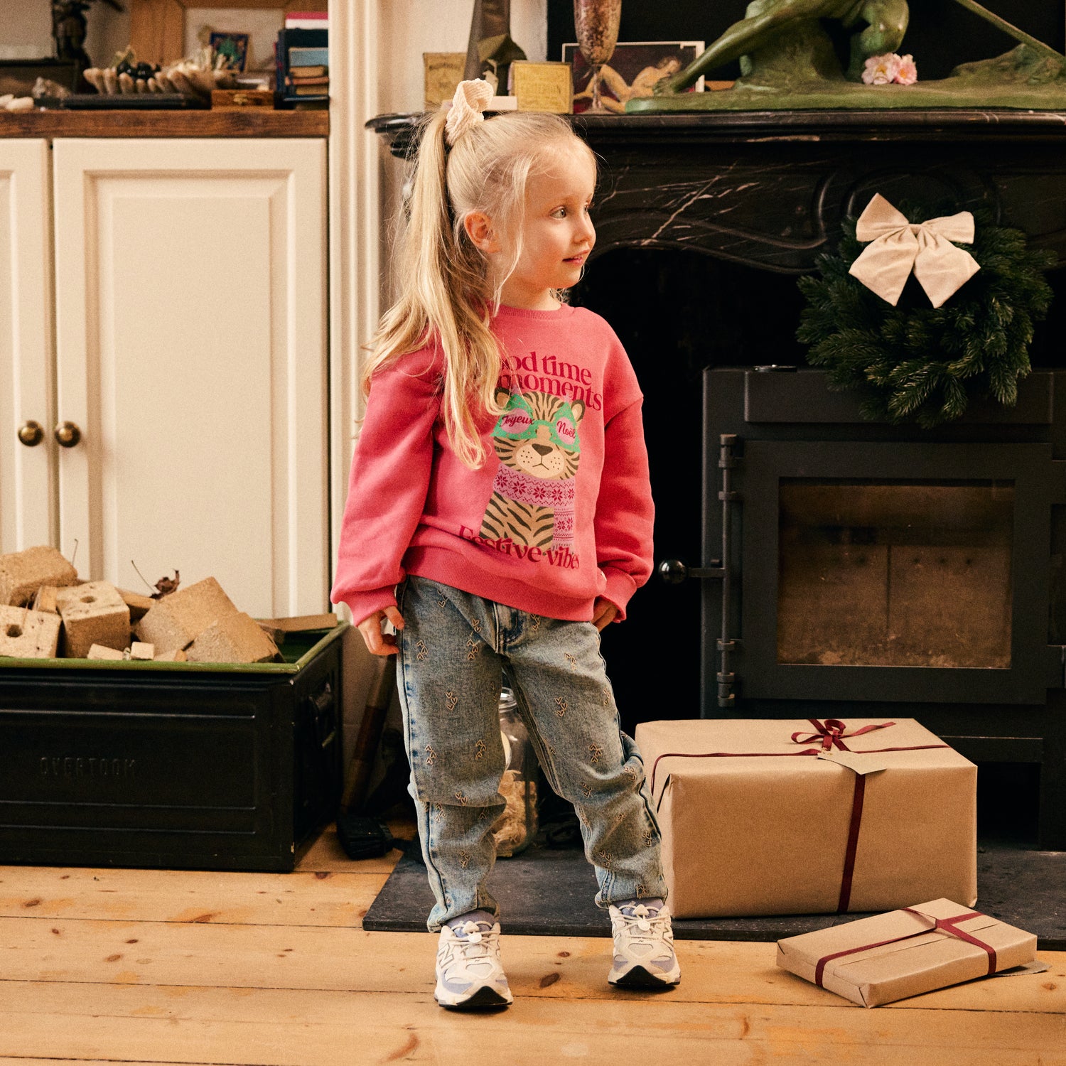 Kind trägt das Daily Seven Weihnachtssweatshirt Pink