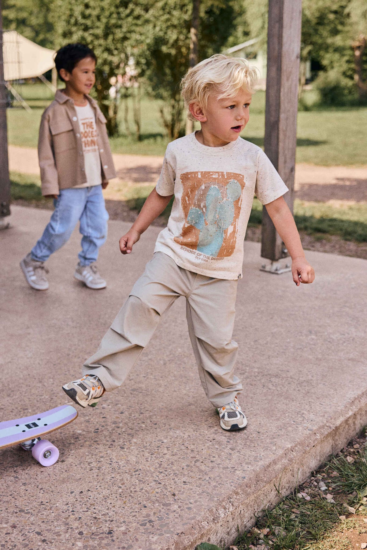 Kind trägt DAILY7KIDS Cactus T-Shirt in Offwhite draussen beim Spielen