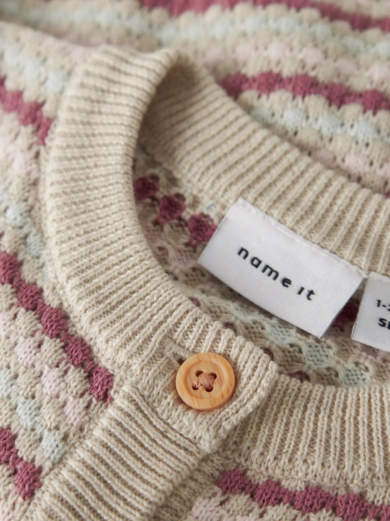 Detailaufnahme Streifenmuster und Knöpfe bei Baby Strickcardigan, erhältlich bei Bärechind Winterthur Zürich Schweiz.