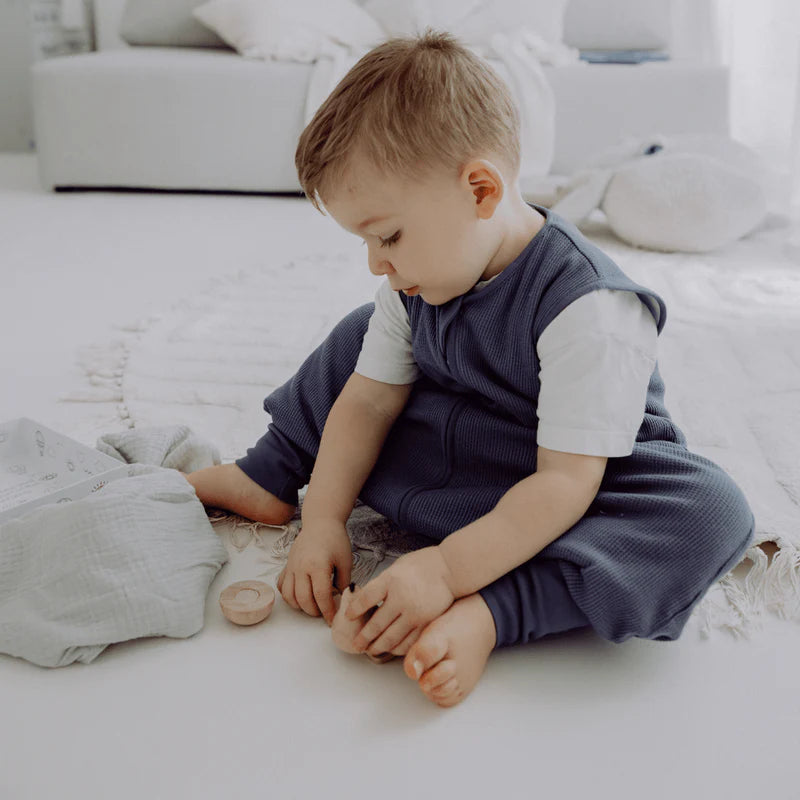 Kind sitzt im Emma & Noah Babyschlafsack mit Füssen blau im Bett, Bärechind Winterthur Zürich Schweiz kaufen