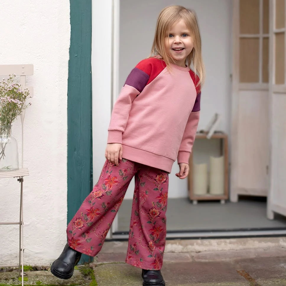 Mädchen trägt das Colourblocking Sweatshirt kombiniert mit weicher Hose