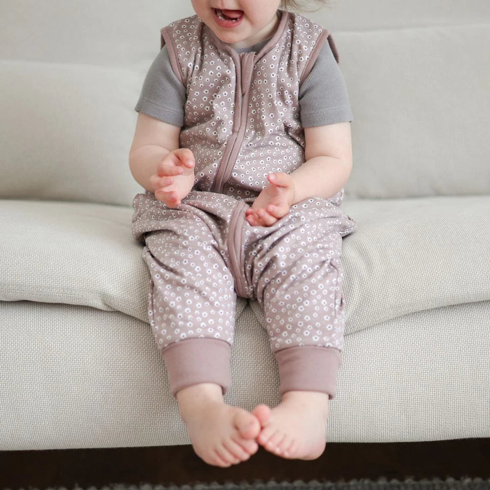 Kind sitzt im Babyschlafsack mit Füssen Blumen berry auf Sofa, Bärechind Winterthur Zürich Schweiz kaufen