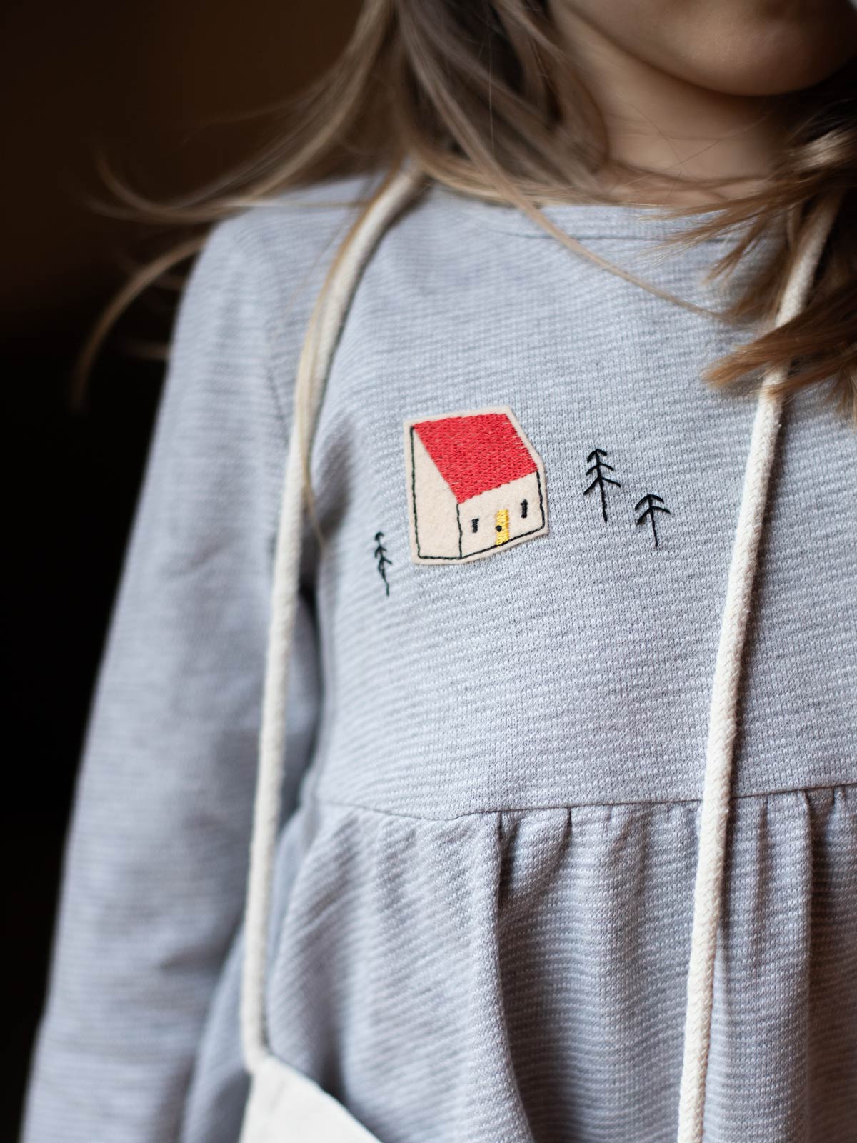 Halfbird Haus Aufnäher auf einem Kinderkleid als kreative Reparatur im Bärechind Winterthur