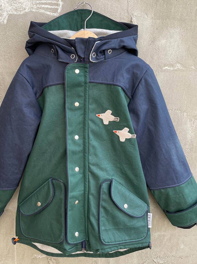 Das Bügelbild Vogel von Halfbird auf einer Kinder-Regenjacke als kreative Verzierung und Reparaturlösung. Erhältlich im Bärechind Winterthur.