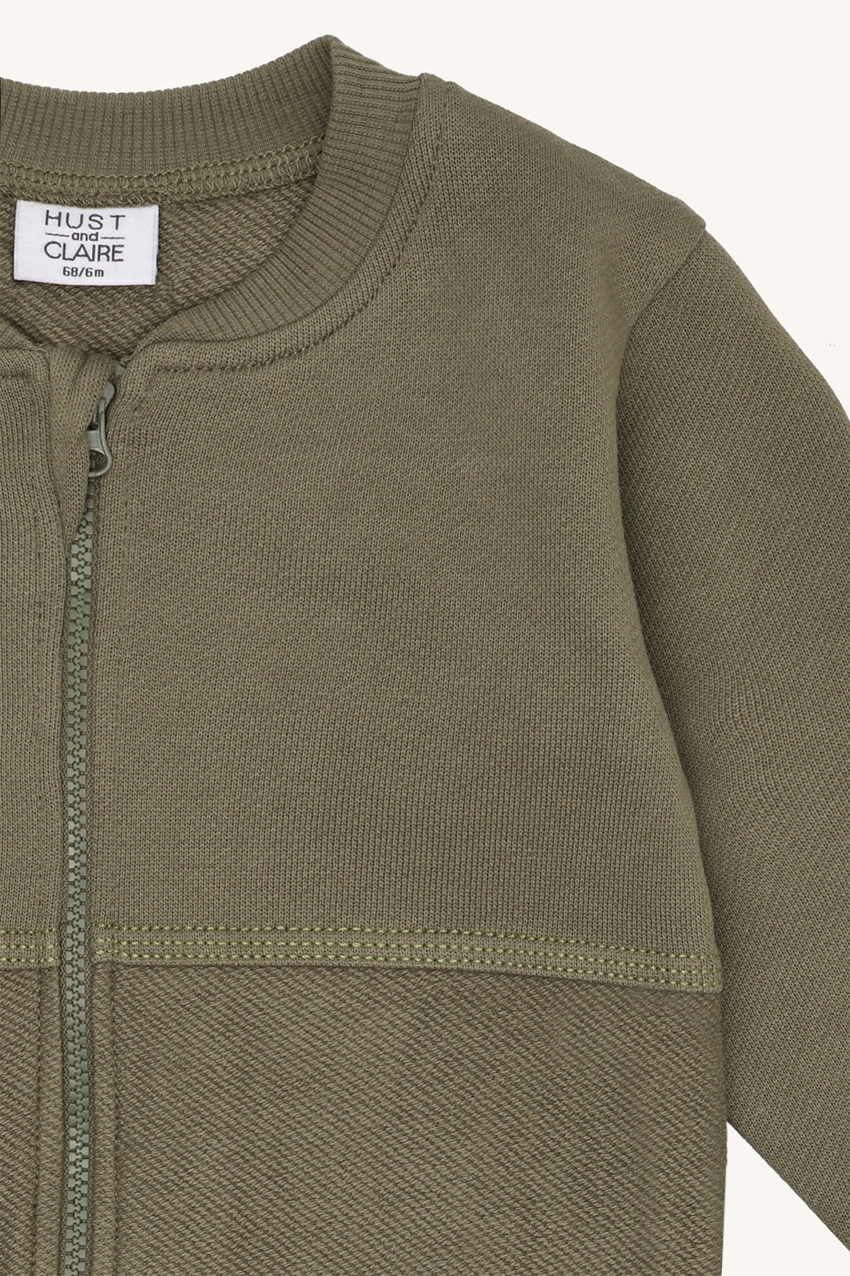 Detail der Hust & Claire Sejer Sweatjacke in Grün mit Reissverschluss, Stehkragen und dekorativen Nähten.