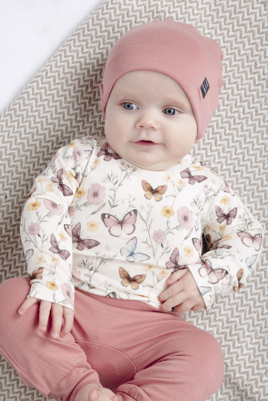Baby trägt Hust&Claire Bambus Langarm Body mit Schmetterlingsprint im Bärechind Kinderladen Winterthur, Zürich, Schweiz.