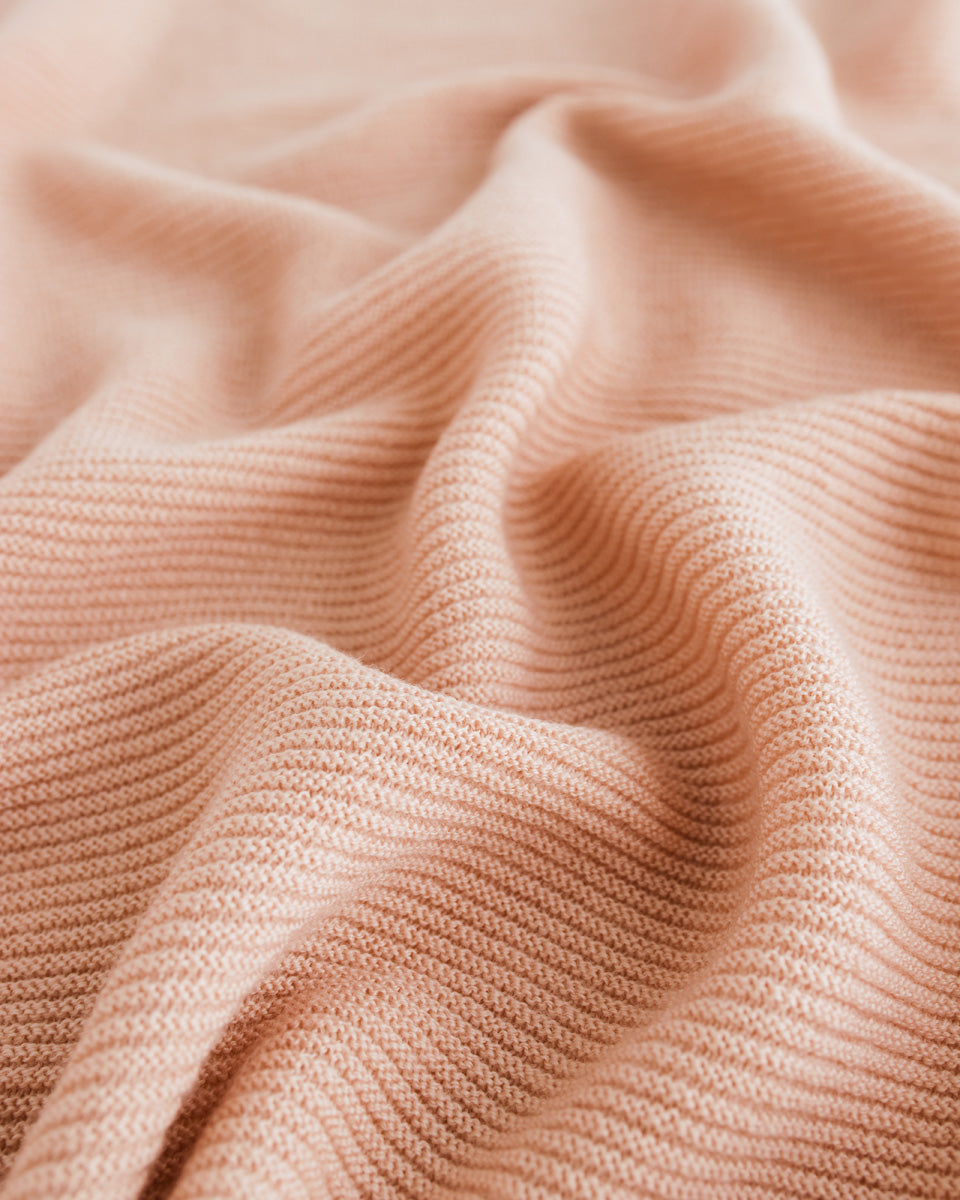 Hvid Merino Babydecke Gusto in Apricot, gestrickt aus mulesingfreier Wolle, erhältlich im Bärechind in Winterthur, Zürich Schweiz.