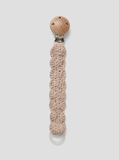 Die Schnullerkette Nino von Hvid aus beiger Merinowolle mit Holzclip ist ein hochwertiges Babyaccessoire und im Bärechind Winterthur erhältlich.