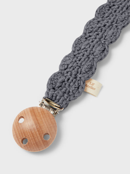 Die Schnullerkette Nino von Hvid aus grauer Merinowolle mit Holzclip ist ein zeitloses Babyaccessoire und im Bärechind Winterthur erhältlich.