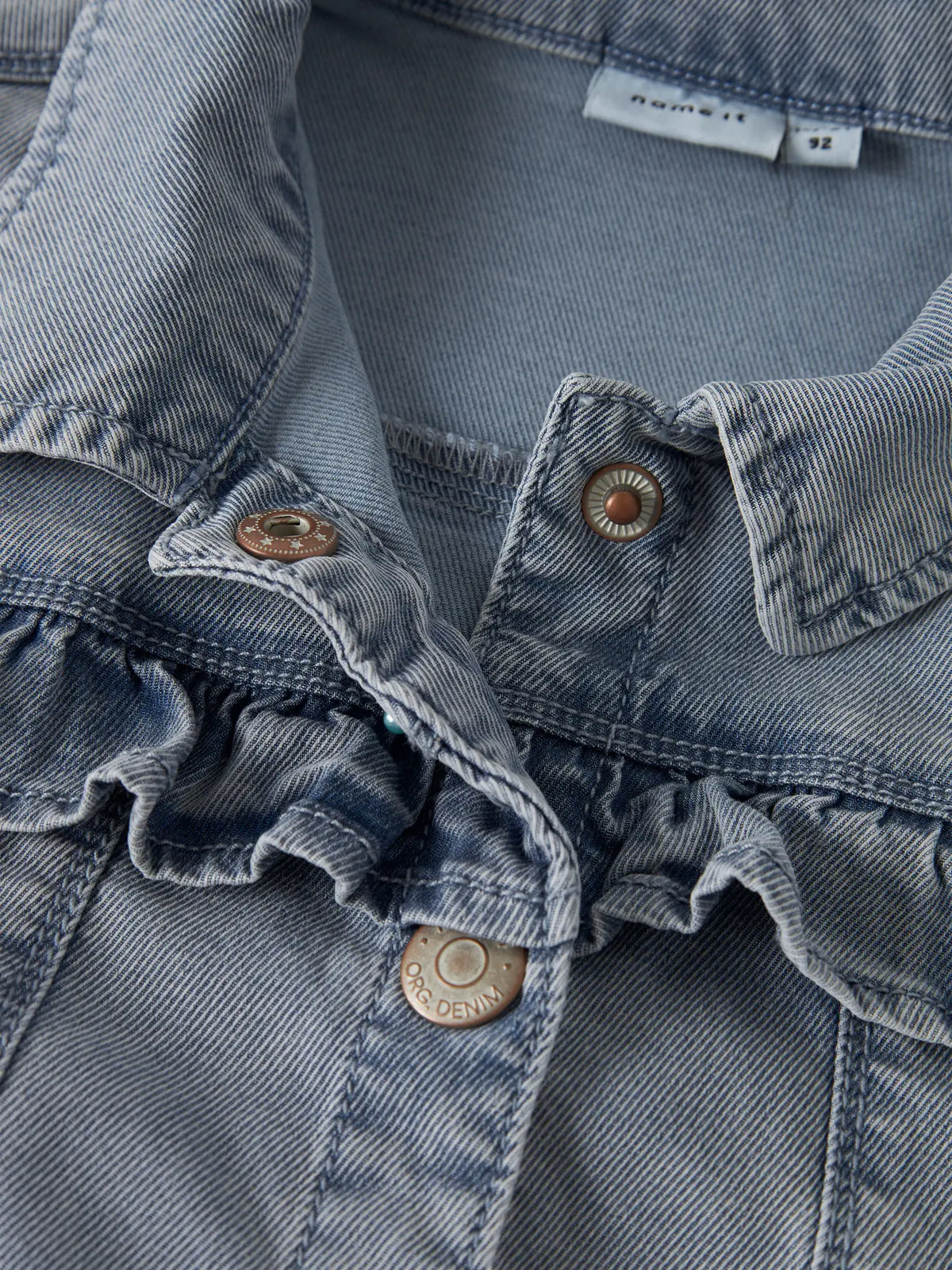 Kind trägt hellblaue Denim Jeansjacke mit Rüschenkragen von NAME IT Bärechind Winterthur Zürich Schweiz