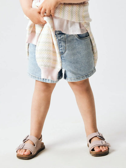 Kind trägt hellblaue Denim Shorts von NAME IT im Sommerlook, erhältlich im Bärechind Winterthur, Zürich, Schweiz.