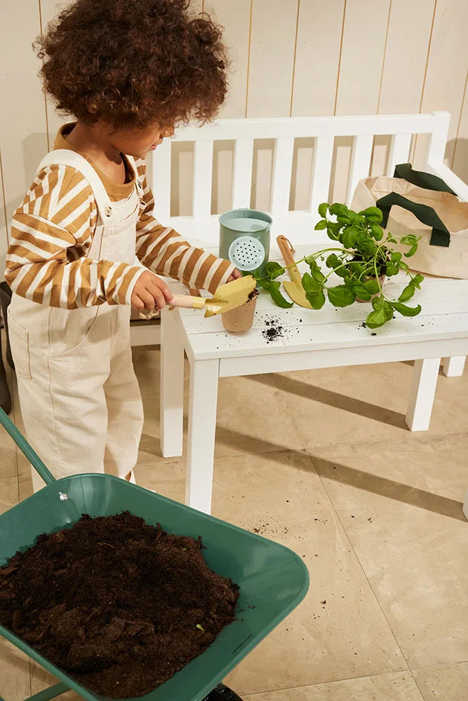 Kind spielt mit Kinder Gartenwerkzeug Set aus Holz und Metall mit Tasche – erhältlich bei Bärechind in Winterthur Zürich Schweiz.