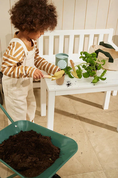 Kind spielt mit Kinder Gartenwerkzeug Set aus Holz und Metall mit Tasche – erhältlich bei Bärechind in Winterthur Zürich Schweiz.