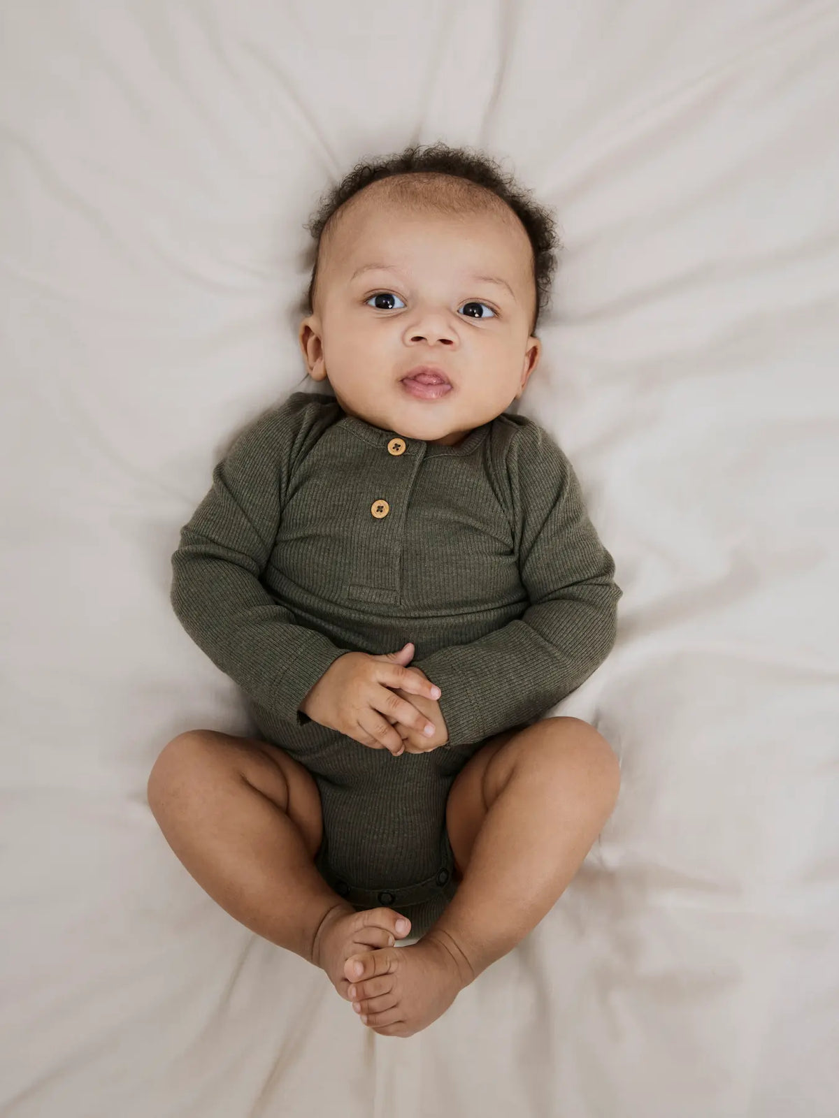 Baby trägt den Langarm Body in Dusty Olive von name it – gemütlich & alltagstauglich