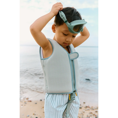 Kind trägt Liewood Dove Schwimmweste mit Streifen Peppermint Sandy am Strand – nachhaltige Kinder Bademode bei Bärechind Winterthur, Zürich Schweiz.