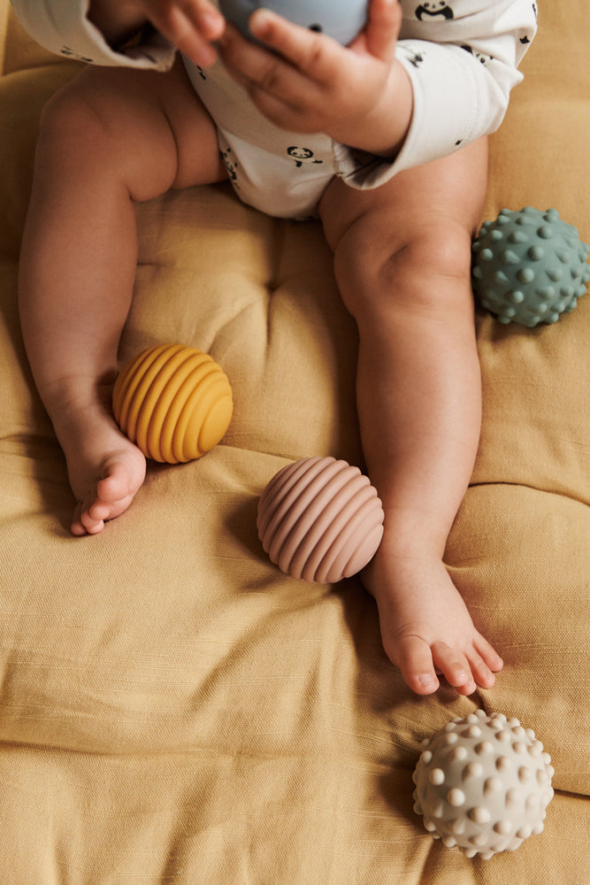 Baby spielt mit Liewood Sensorikbällen aus Silikon, nachhaltiges Babyspielzeug im Bärechind Winterthur Zürich Schweiz.