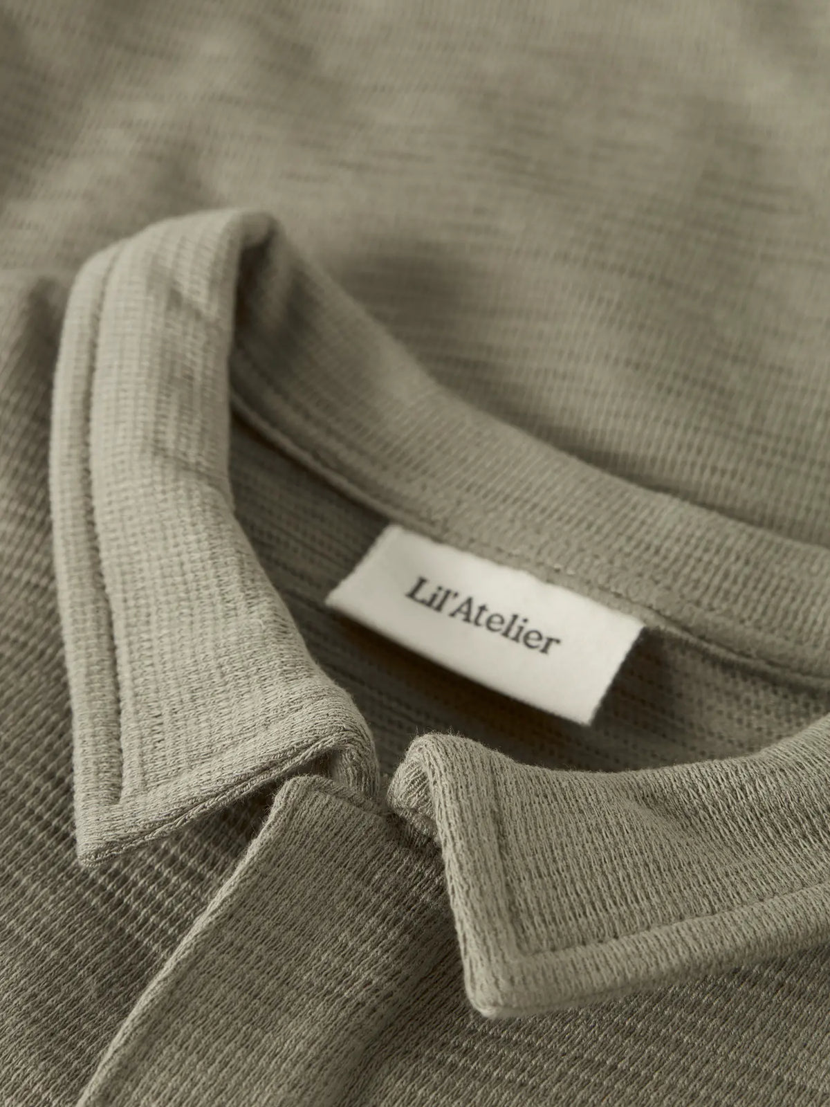 Detail Polokragen Baby Body in olive aus Baumwolle von Lil' Atelier im Bärechind Kinderladen Bärechind Winterthur Zürich Schweiz