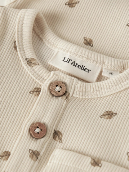 Detailaufnahme des LIL' ATELIER Ripp Bodys aus Baumwolle und TENCEL™ Lyocell mit Planetenprint, Knopfleiste und Brusttasche