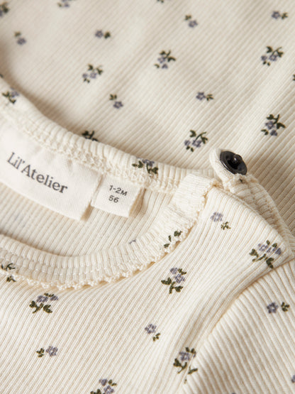 Detailaufnahme der Rippstruktur und des Blümchenmusters am Lil' Atelier Body, erhältlich im Bärechind.