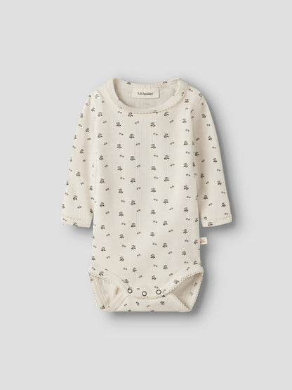 Lil' Atelier Rippbody in Creme mit feinem Blümchenmuster und langen Ärmeln.