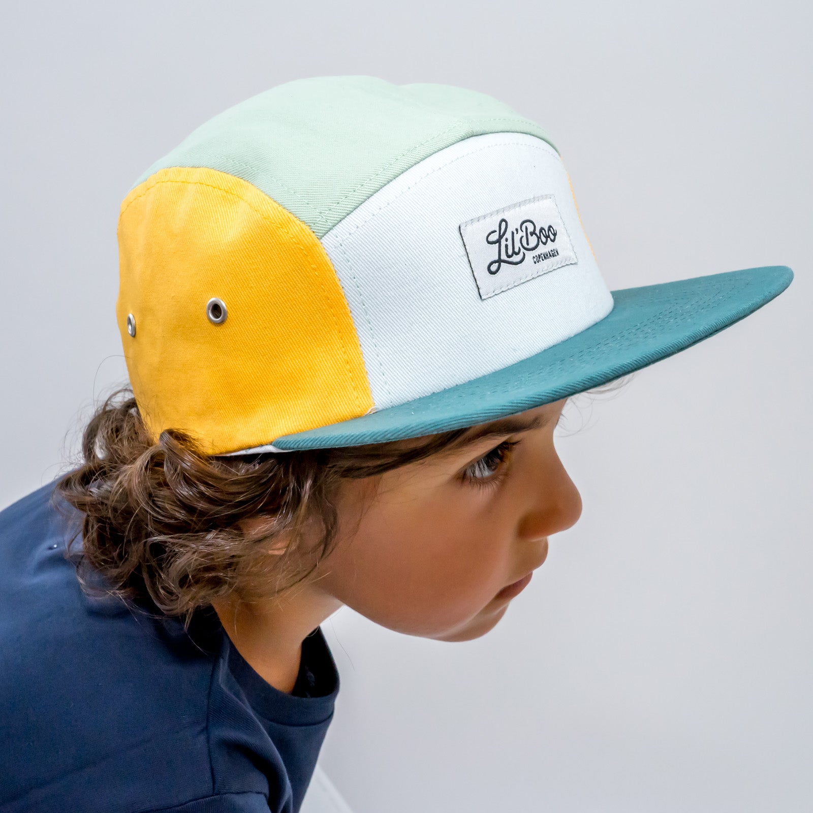 Kind trägt Lil Boo Kinder Cap Block Yellow Green Sommer Cap aus Bio Baumwolle