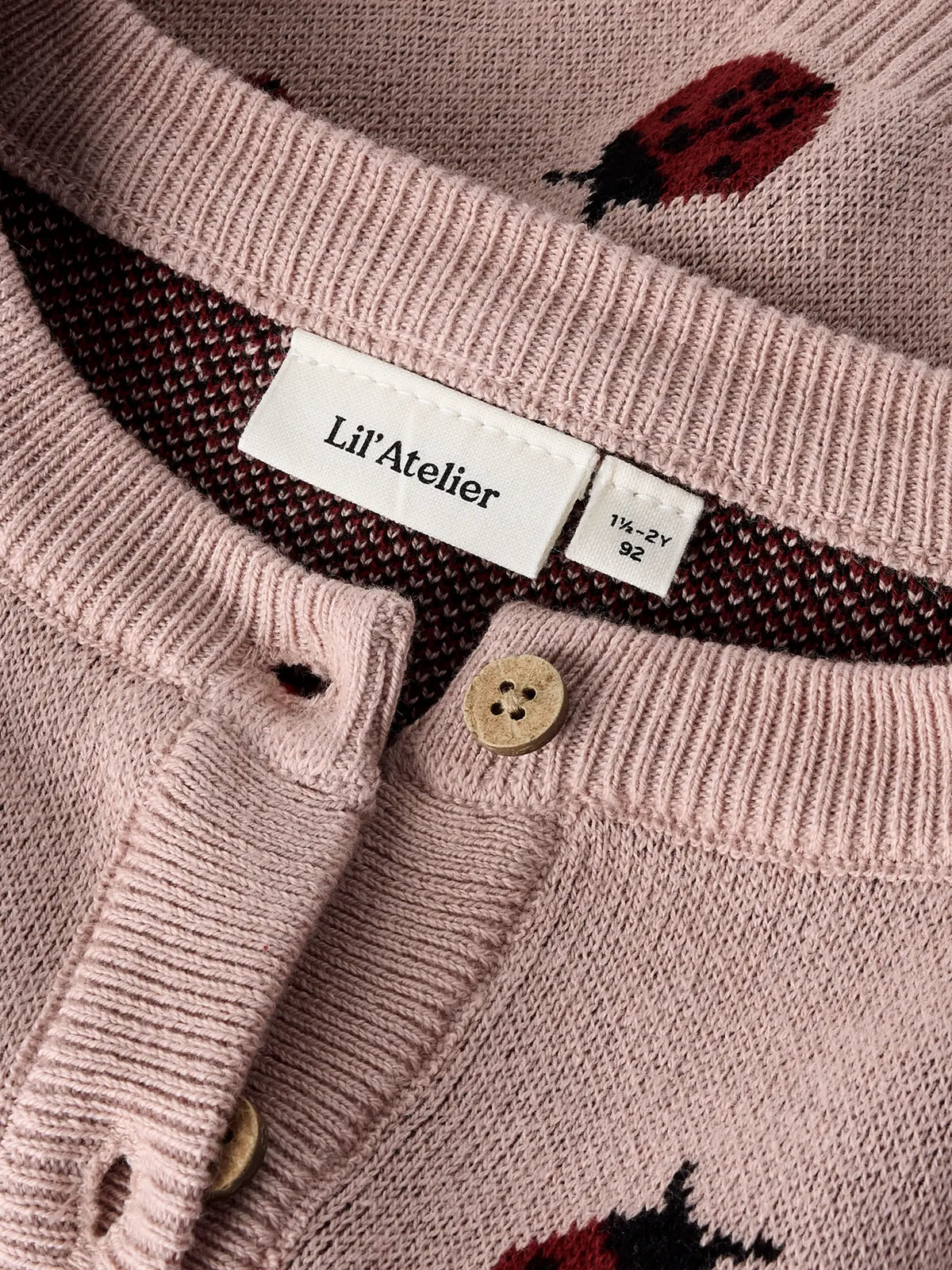 Detailaufnahme von Marienkäfermuster und Knopfleiste der LIL'ATELIER Strickjacke bei Bärechind Winterthur Zürich Schweiz