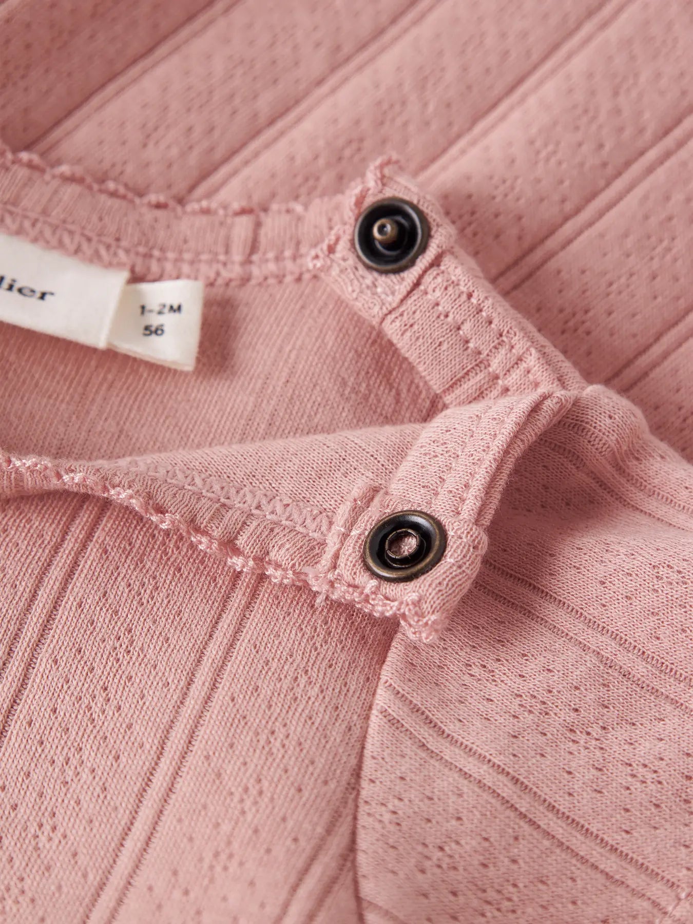 Detailaufnahme Druckknöpfe am Lil' Atelier Baby Bodykleid aus Bio-Baumwolle bei Bärechind Winterthur Zürich Schweiz.