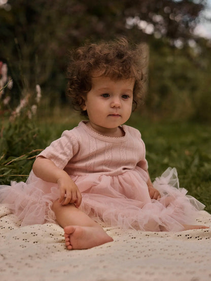 Baby trägt festliches rosa Bodykleid mit Tüll von Lil’Atelier bei Bärechind in Winterthur, Zürich, Schweiz