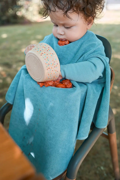 Kind trägt das wasserdichte Little Casimir Lätzchen Boo Dusty Ocean mit Ärmeln beim Essen und Spielen, erhältlich im Bärechind Winterthur