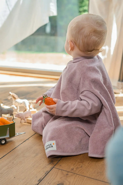 Kind trägt das wasserdichte Little Casimir Lätzchen Boo Lilac Love in Altrosa beim Essen und Spielen, erhältlich im Bärechind Winterthur